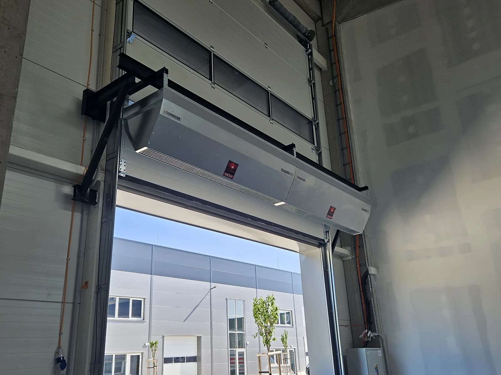 Industrial air curtain mounted above a commercial door opening at a Canadian facility
