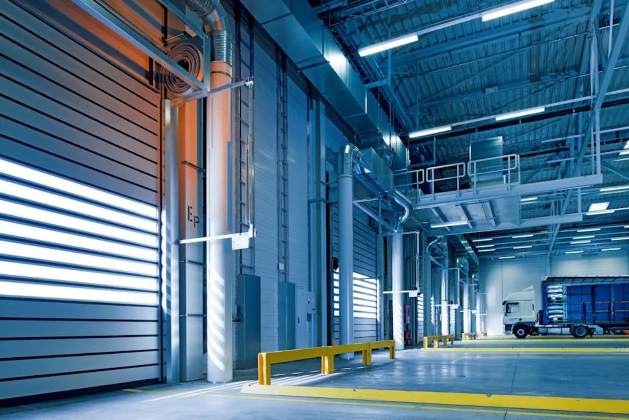 Loading-dock commercial doors at a Canadian distribution warehouse with sectional overhead panels